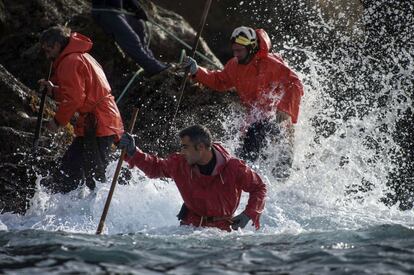 Varios 'percebeiros' fotografiados en plena actividad en las rocas en las bahía de Vigo, en el municipio de Cangas de Morrazo (Galicia).