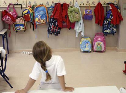 Una niña mira las mochilas de sus compañeros en su primer día de clase.