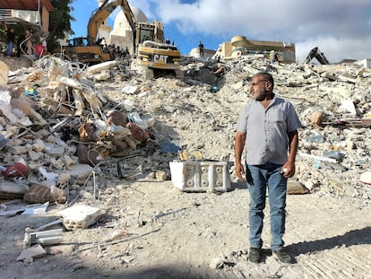 Mustafa Qalqas stands in front of the rubble of a bombed building in Ain El Delb, on 30 September.