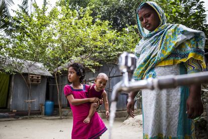 A largo plazo, los sistemas de canalización de agua son una solución al problema. En la foto, Golapi, su hija Chinta Moni, de siete años, y Tamim, de cinco meses, cogen agua potable de uno de estos sistemas.

