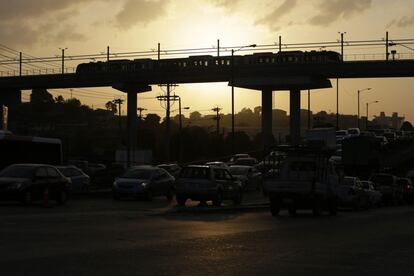 El sol se pone sobre el viaducto que sostiene los raíles del metro.