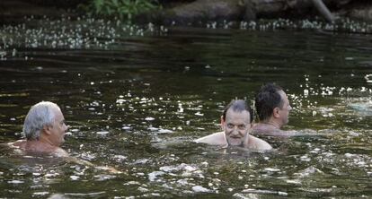 Mariano Rajoy (2d), durante sus vacaciones de verano de 2015, dándose un baño con unos amigos en Pontevedra