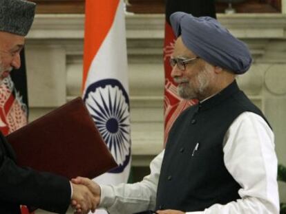 Hamid Karzai y Manmohan Singh se saludan tras firmar el acuerdo bilateral.