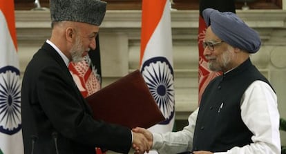 Hamid Karzai y Manmohan Singh se saludan tras firmar el acuerdo bilateral.