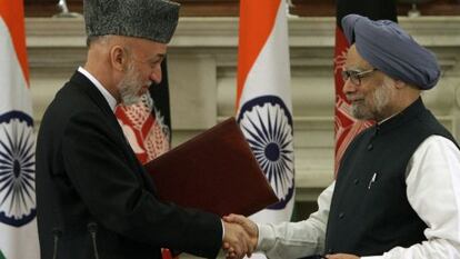 Hamid Karzai y Manmohan Singh se saludan tras firmar el acuerdo bilateral.