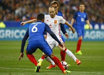 Andrés Iniesta es presionado por el jugador francés Corentin Tolisso.