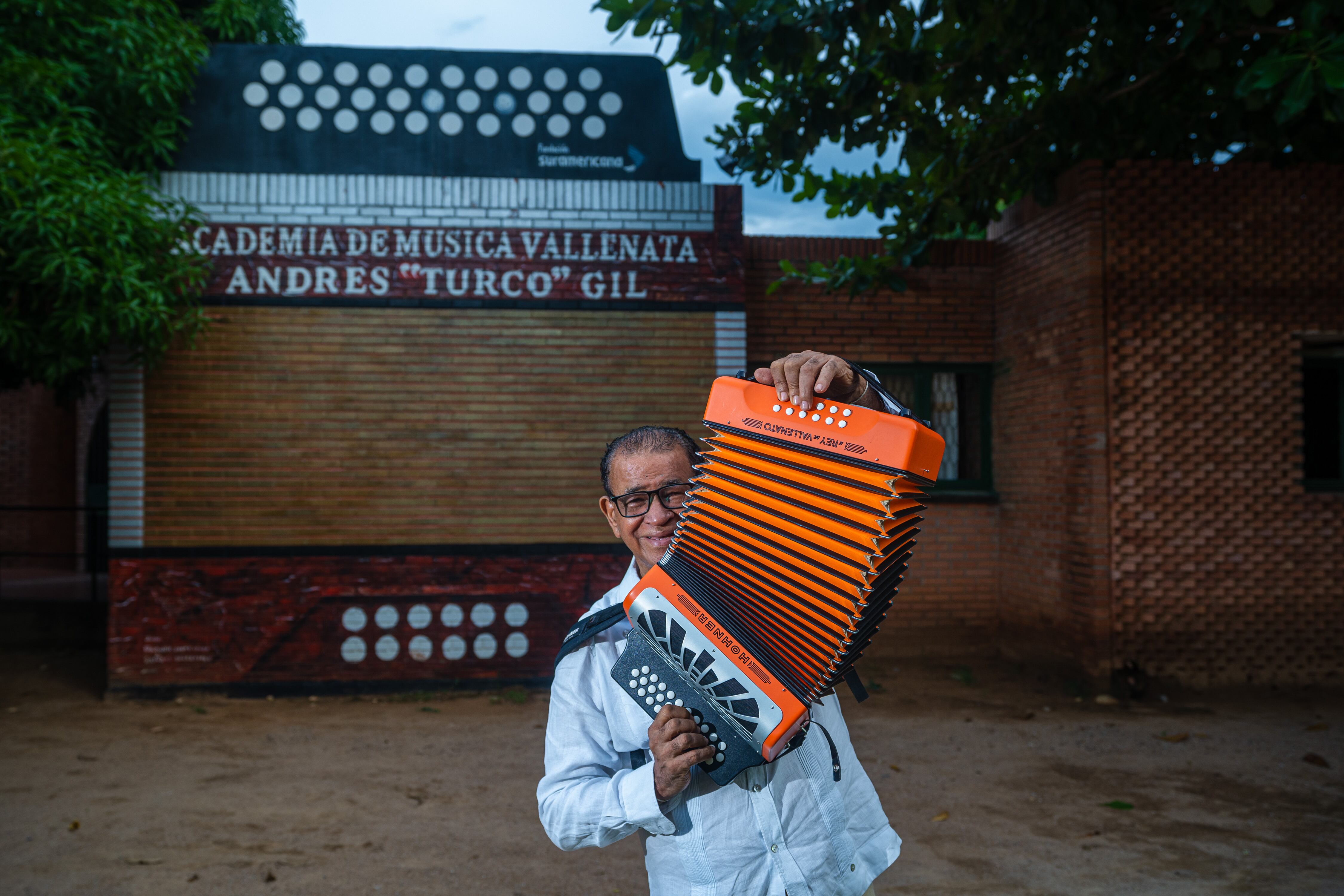 El “Turco” Gil posa para un retrato al frente de la academia, en la capital del vallenato.