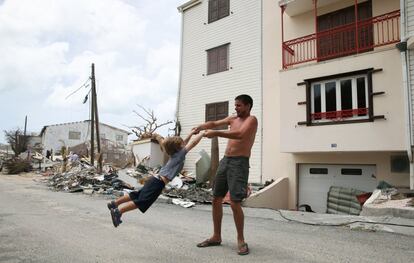 En la imagen, un hombre juega con un niño rodeado por los escombros provocados por el huracán Irma, en Grande Case, en San Martín.