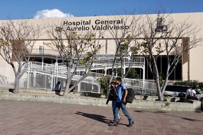 Jóvenes caminan frente al hospital en el que se encontraba hospitalizado el menor, en la Ciudad de Oaxaca.