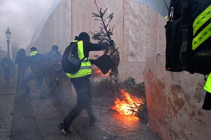 Un manifestante quema árboles de Navidad durante la protesta de los 'chalecos amarillos' en París (Francia).