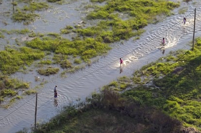 Vista aérea de una zona inundada en la ciudad argentina de La Plata donde unos niños se divierten, con el agua caída por las fuertes lluvias.