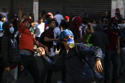 Um jovem opositor se prepara para lançar uma pedra na polícia durante os confrontos em Caracas.