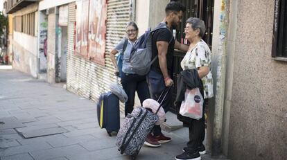 Turistas con maletas entran en un portal de Madrid. 