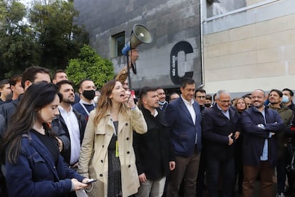 Júlia Calvet, presidenta de S´ha acabat, habla por el micrófono rodeada de miembros de la entidad y líderes políticos.