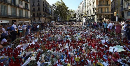 Cientos de personas, congregadas en La Rambla de Barcelona, depositan velas, flores y mensajes de apoyo y recuerdo a las v&iacute;ctimas del atentado.