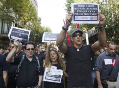 Varias personas portan pancartas durante la manifestación que empleados de Catalunya Banc llevaron a cabo el pasado 5 de septiembre  por el centro de Barcelona para protestar contra el ERE. EFE/Archivo