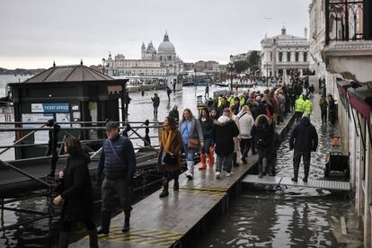 Los turistas se han visto forzados a usar las pasarelas para desplazarse por Venecia por la inundación de la ciudad.