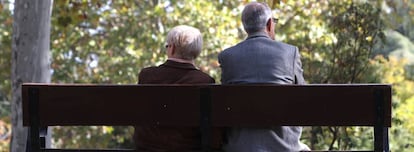 Dos ancianos sentados en el banco de un parque público de Madrid.