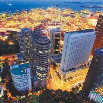 Vista aérea y nocturna del centro de Singapur, con el puerto al fondo