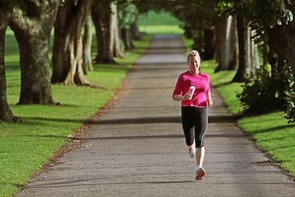 Una mujer corre por un parque.