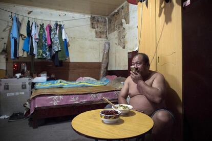 En la foto, un residente que trabaja en una empresa de transporte habla por teléfono mientras cena en su casa del barrio cercano al 'Silicon Valley' de Pekín.