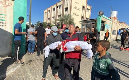 Un padre carga a su hijo tras un ataque de Israel en el sur de Gaza