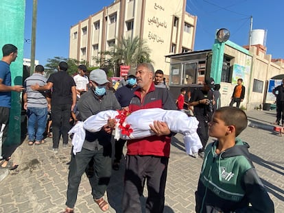 Un padre carga a su hijo tras un ataque de Israel en el sur de Gaza este jueves 26 de octubre.