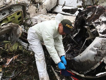 Un agente de la policía trabaja cerca de los restos del avión siniestrado en La Unión (Colombia).