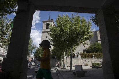 Un niño pasa por delante de la parroquia de la Asunción, en Valdemorillo.