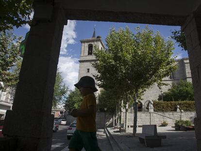 Un niño pasa por delante de la parroquia de la Asunción, en Valdemorillo.