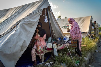 Unas mujeres permanecen cerca de una tienda en un campamento improvisado después de huir de sus casas azotadas por las inundaciones en el distrito de Charsadda, este lunes.