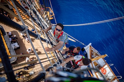 Los miembros del Luna Rossa ascienden por las cuerdas del velero Amerigo Vespucci. 