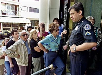 Un policía vigila la entrada del Banco de la Nación, donde continúan las largas colas de ciudadanos atrapados en el <i>corralito</i>.