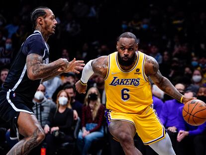 LeBron James pasa al lado de James Johnson durante el partido de los Lakers contra los Nets.