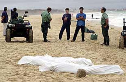 Los cuerpos de dos de los inmigrantes fallecidos aparecen cubiertos en una playa de Tarifa.