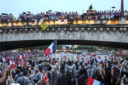 Los atletas franceses reciben el cariño del público a su paso por uno de los puentes del río Sena. 