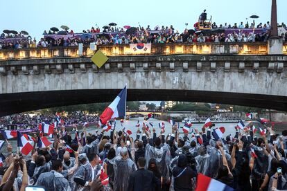 Los atletas franceses reciben el cariño del público a su paso por uno de los puentes del río Sena. 