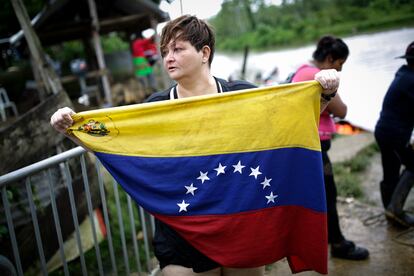 Karina Silva, una médica cirujana venezolana de 41 años, muestra la bandera de Venezuela a su llegada el 13 de octubre de 2022, al pueblo de Bajo Chiquito (Panamá), tras cruzar la selva del Darién