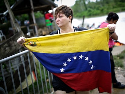 Karina Silva, una médica cirujana venezolana de 41 años, muestra la bandera de Venezuela a su llegada el 13 de octubre de 2022, al pueblo de Bajo Chiquito (Panamá), tras cruzar la selva del Darién