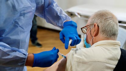 Una sanitaria pone la vacuna contra la covid-19 a un residente de un geriátrico público.