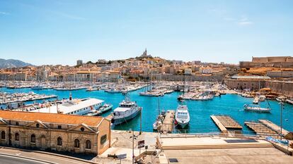 Marsella (Francia). Esta es una ciudad marcada por la diversidad: es playera y urbana; es francesa y mediterránea; es moderna e histórica. A unos les atrae por la proximidad de las playas de la Costa Azul y a otros por su cercanía a la región de Provenza, pero por sí misma es una ciudad a descubrir, con barrios muy diversos, interesantes circuitos arquitectónicos y de arte urbano, además de un nuevo museo con pinturas rupestres que ha enriquecido su amplia oferta cultural. Cada barrio cuenta con su propia personalidad y encanto con un denominador común: buena gastronomía. Conviene empezar la visita por el centro, o mejor aún, por la basílica de La Bonne Mère, de estilo románico bizantino, coronada por una estatua dorada de la virgen. Desde allí, en el punto más alto de la ciudad, se contemplan vistas de 360 grados. Ya solo hay que bajar hasta el otro icono de la ciudad, el Vieux-Port, hoy lleno de embarcaciones de recreo. Invita a dar un paseo tranquilo, e incluso a comer en uno de sus míticos restaurantes descubriendo los platos marselleses, como su mítica bullabesa. La atracción más nueva de la ciudad es la Grotte Cosquer, con realistas reproducciones de pinturas rupestres de 27.000 años de antigüedad. Al lado está el Museo de las Civilizaciones, inaugurado en 2013. Para quien quiera salirse del circuito turístico, en barrios como Cours Julien y Le Panier el arte urbano se ha convertido en parte de la ciudad, y hay circuitos de grafitis, pero también de compras por mercados y tiendas antiguas. Y una recomendación más para los más interesados por la vanguardia cultural: el Friche la Belle de Mai, una antigua fábrica de tabaco convertida en centro cultural que acoge estudios de artistas, salas de exposiciones, una librería, un 'skatepark', un restaurante y una amplia terraza en la azotea. Al otro lado de la ciudad, la Unité d’Habitation en La Cité Radieuse —la utópica visión del arquitecto Le Corbusier de una vivienda de uso mixto que recuerda a un crucero de hormigón— es de visita obligada para los amantes de la arquitectura.
Además, Marsella queda enmarcada por dos pintorescos pueblos pesqueros. En el extremo sur está Les Goudes, una combinación muy 'instagrameable' de paseos rocosos, calas para nadar y 'cabanons' (casetas de playa). Se puede saborear pescado fresquísimo en una mesa junto al mar en alguno de sus bares y chiringuitos. Y en el extremo norte, L’Estaque, que evoca el pasado industrial y artístico de Marsella: con sus fábricas y su luz provenzal, en otros tiempos cautivó a pintores como Cézanne.