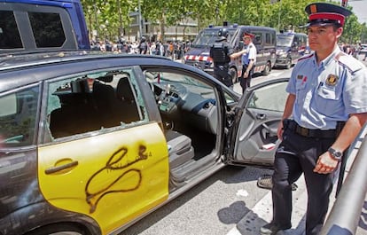 Un taxi destrozado durante la protesta de ayer del sector en la Diagonal de Barcelona.