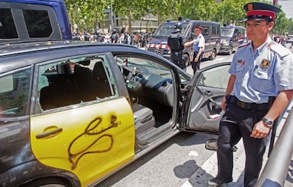 Un taxi destrozado durante la protesta de ayer del sector en la Diagonal de Barcelona. 