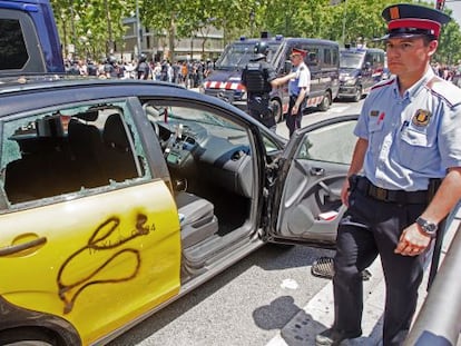 Un taxi destrozado durante la protesta de ayer del sector en la Diagonal de Barcelona. 