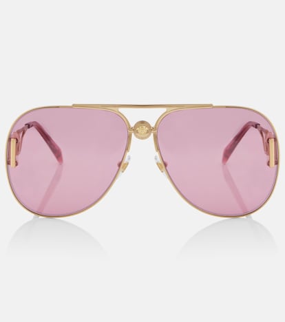 La clásica silueta de aviador se transforma con estas gafas de sol de Versace en un accesorio de moda imprescindible gracias a sus lentes de color rosa y a la medusa que corona el puente de la nariz.