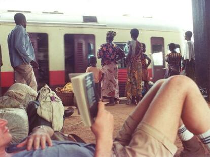 Bruce Chatwin (tumbado), uno de los grandes escritores de literatura de viajes, en una estaci&oacute;n de Ben&iacute;n. 