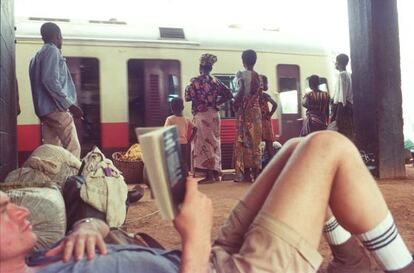 Bruce Chatwin (tumbado), uno de los grandes escritores de literatura de viajes, en una estaci&oacute;n de Ben&iacute;n. 