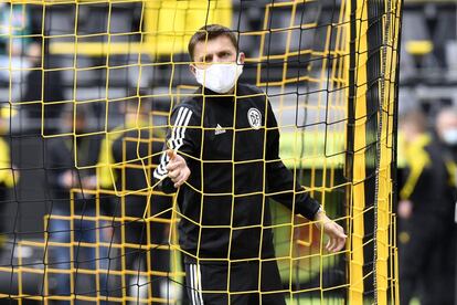 El árbitro Deniz Aytekin, con mascarilla, revisa el estado de las redes de una de las porterías antes del Dortmund-Schalke 04.