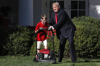 Donald Trump, este viernes en los jardines de la Casa Blanca junto a un niño que le había escrito pidiéndole cortar el césped.