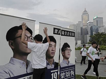 Un ciutadà subjecta diversos cartells electorals a Hong Kong.